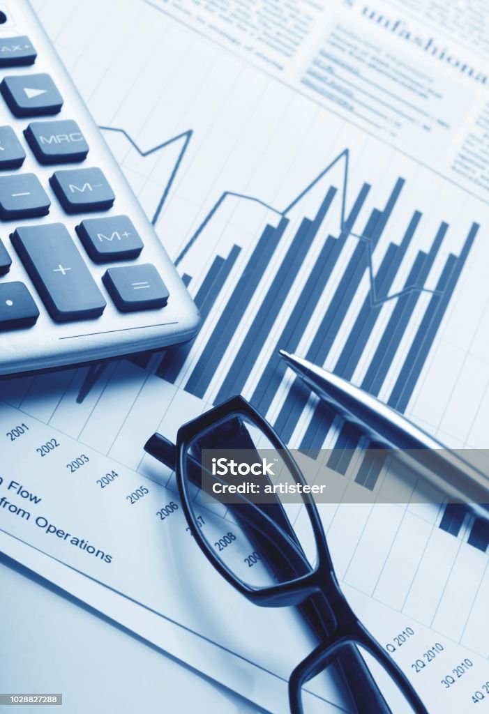 Calculator, Pen and Eyeglasses on Business Graphs
